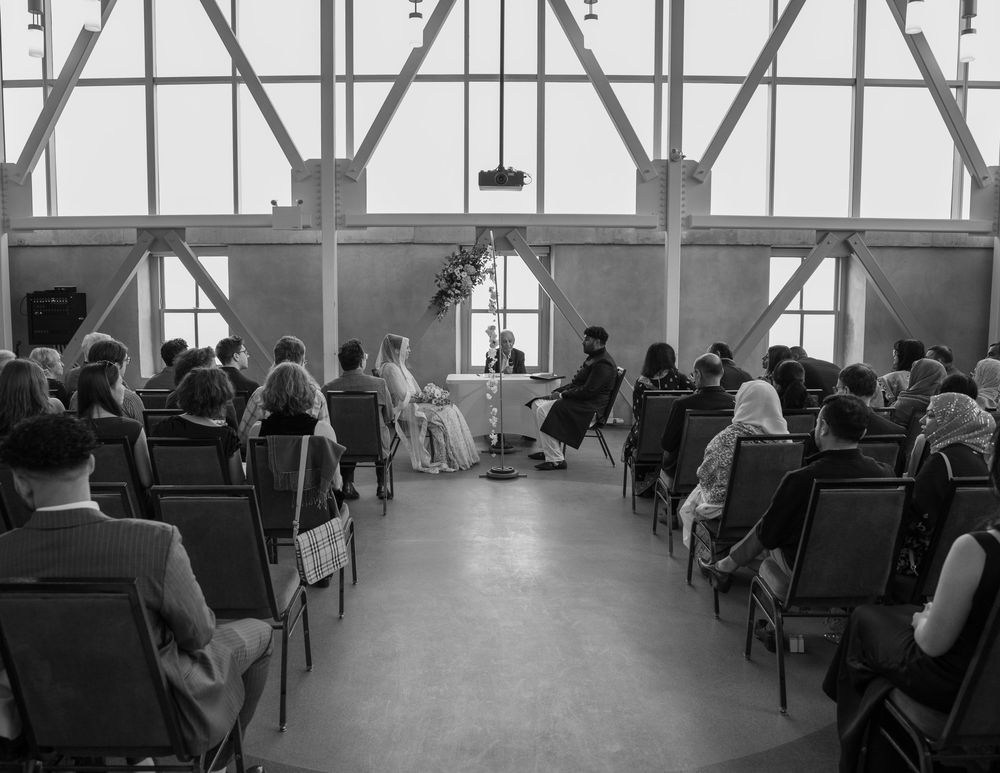 Couple échangeant leurs vœux dans la salle Malting Tower du Tett Centre à Kingston, lumière naturelle et décor élégant.