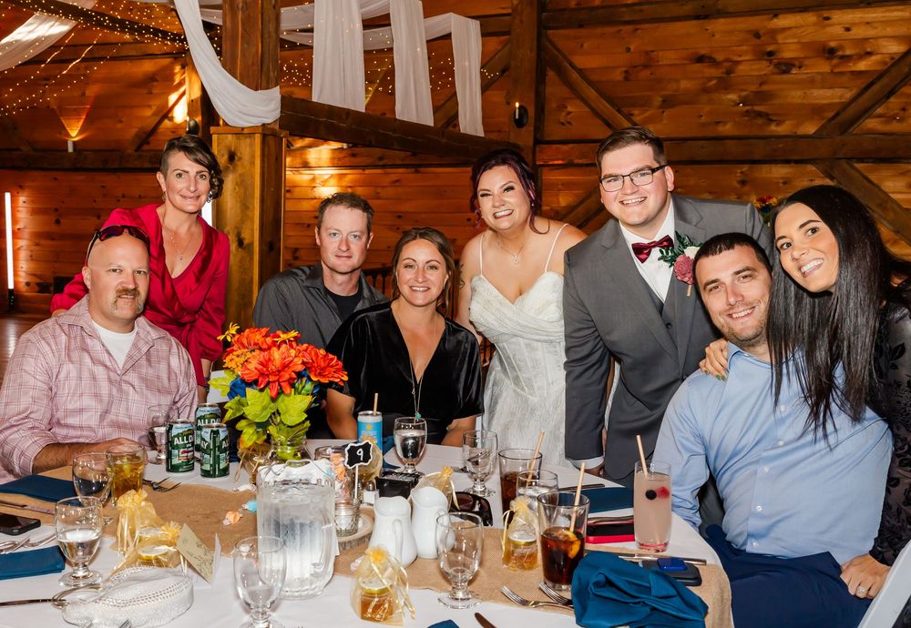 A group of people enjoying dinner and drinks together at a rustic restaurant with wooden decor.
