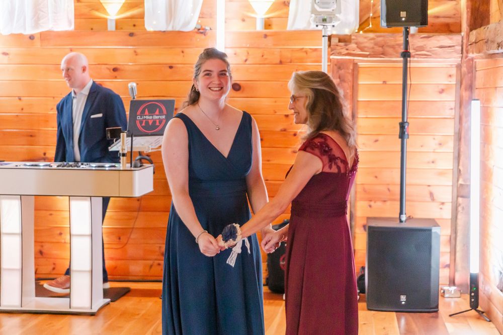 Wedding guests dancing and celebrating at a rustic wooden cabin venue during a reception.