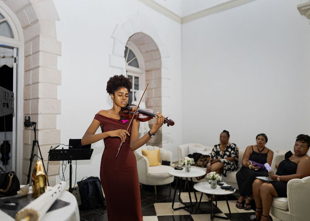Musicians perform together in a white-walled studio space during a recording session.