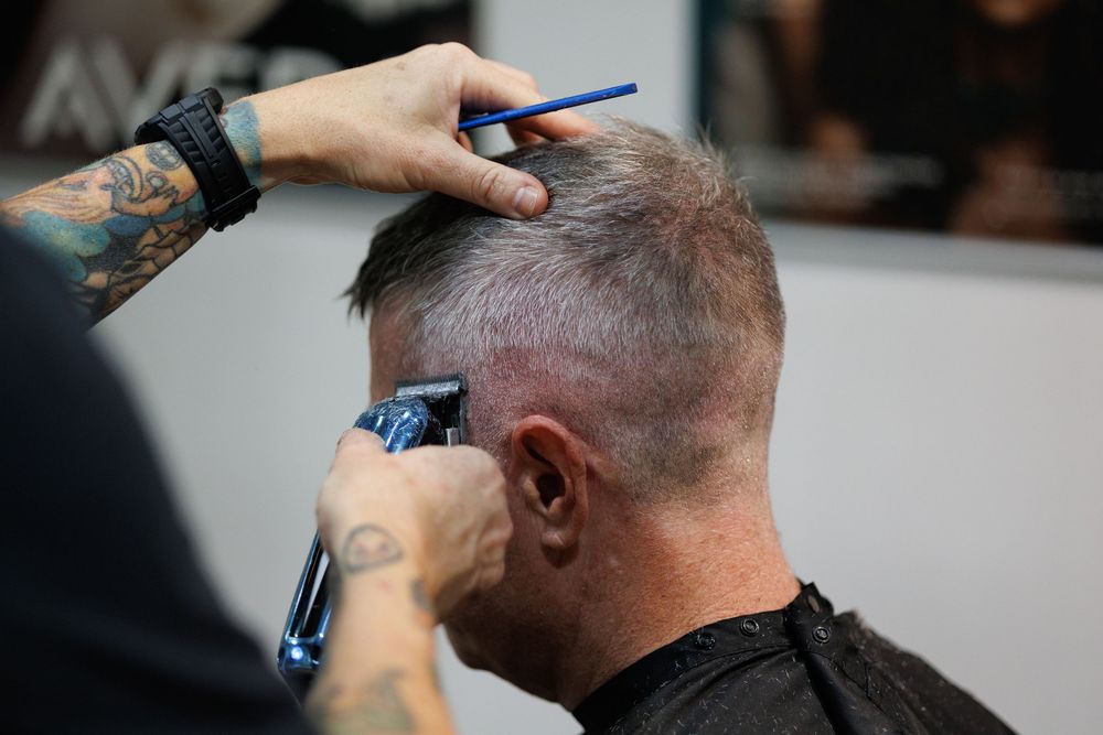Close-up of precision haircut being performed with professional tools.
