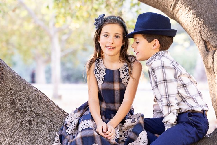 Two children sit together under a tree on a sunny afternoon in Los Gatos.