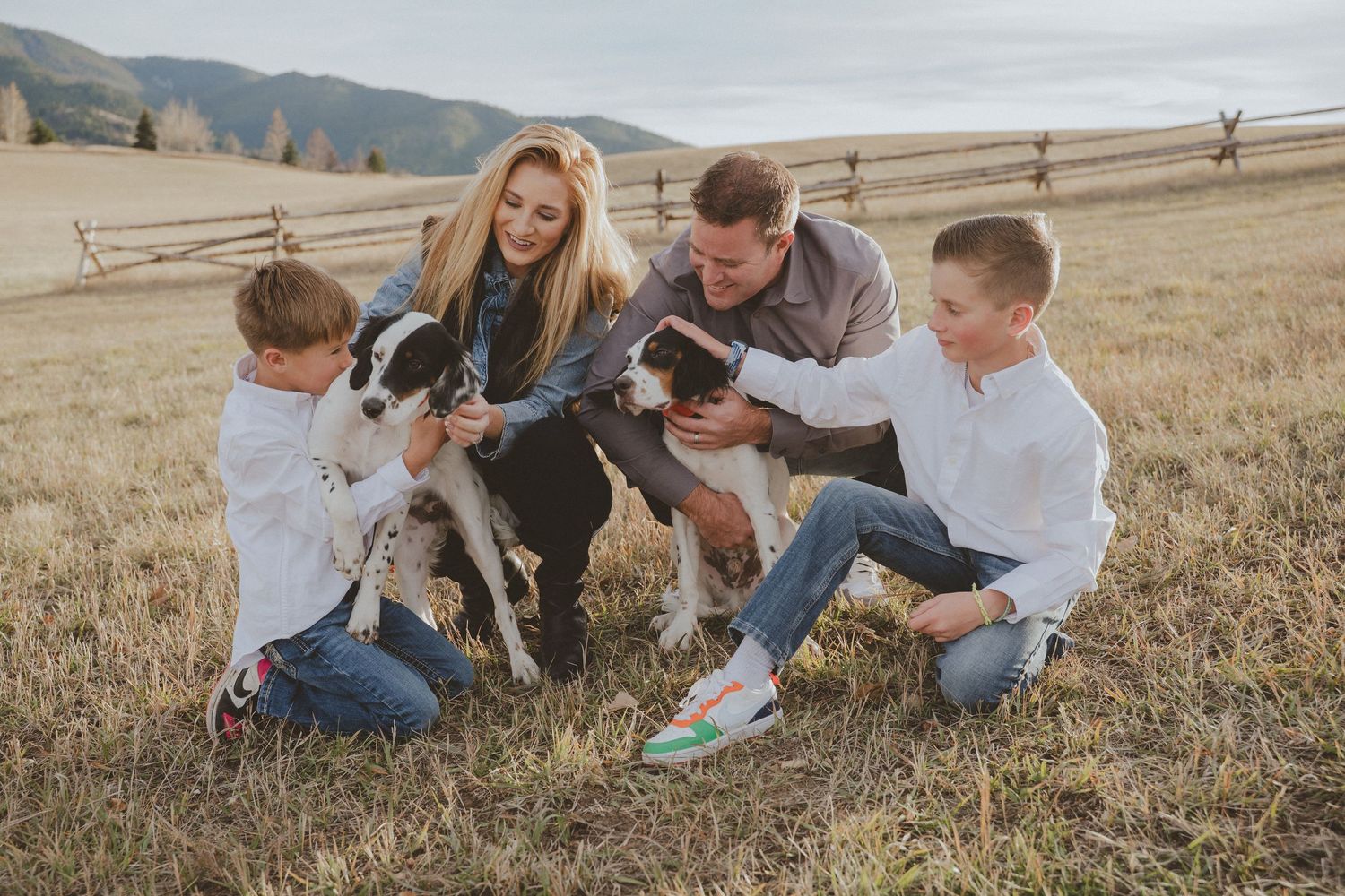 Family enjoying casual moments together in a mountain field setting.