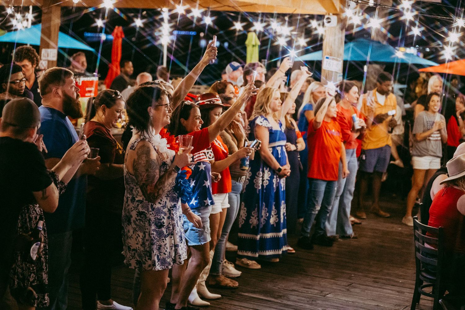 A large crowd of spectators watches and cheers at an outdoor celebration or event.