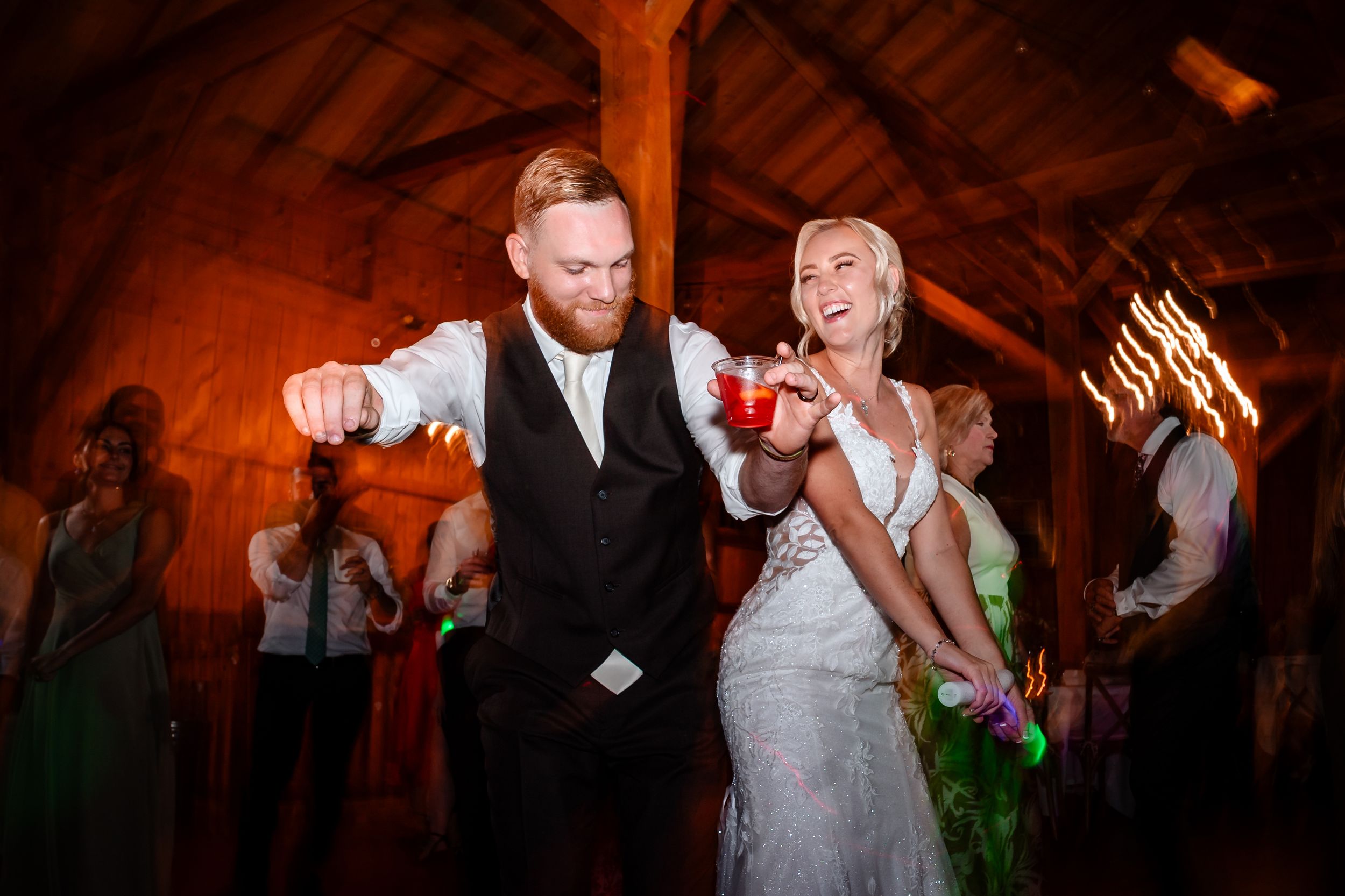Lively dance floor moments captured during barn wedding reception.