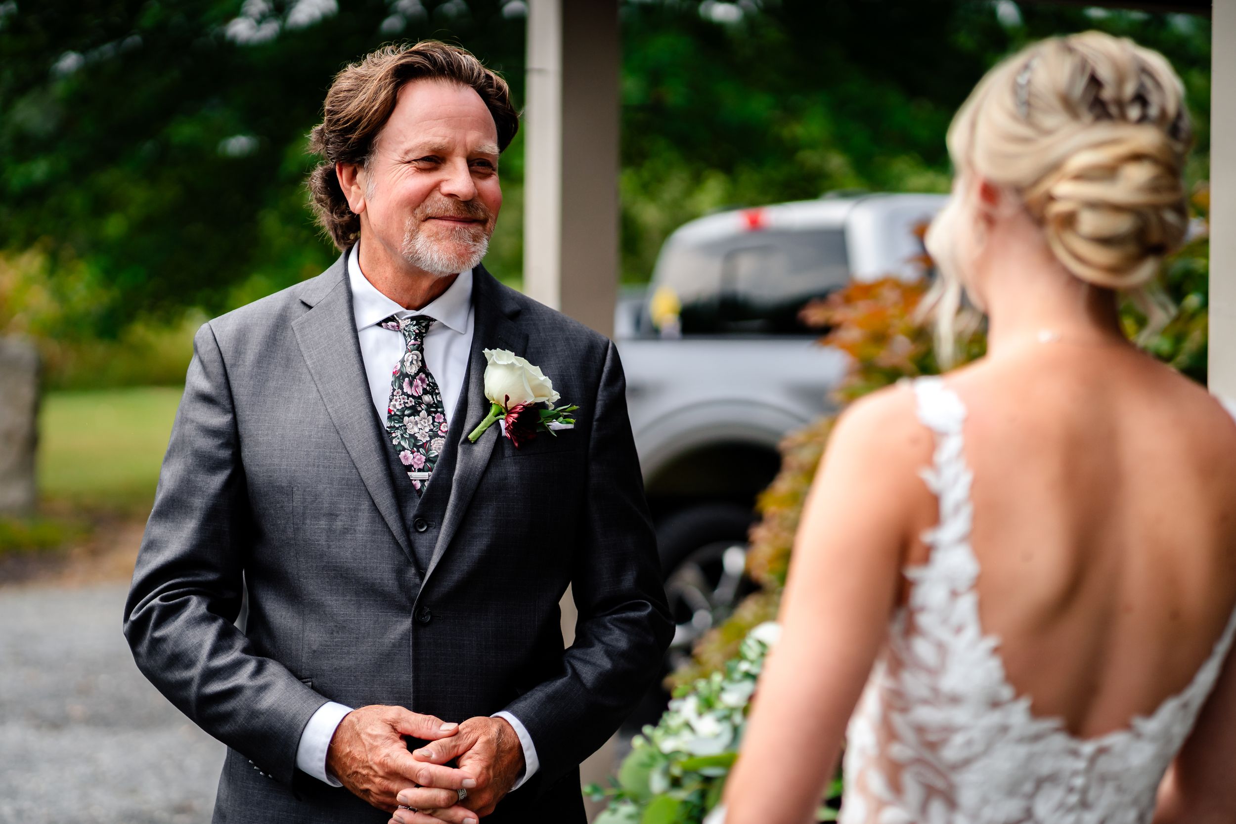 Outdoor wedding portraits taken on a porch with white columns and greenery in background.