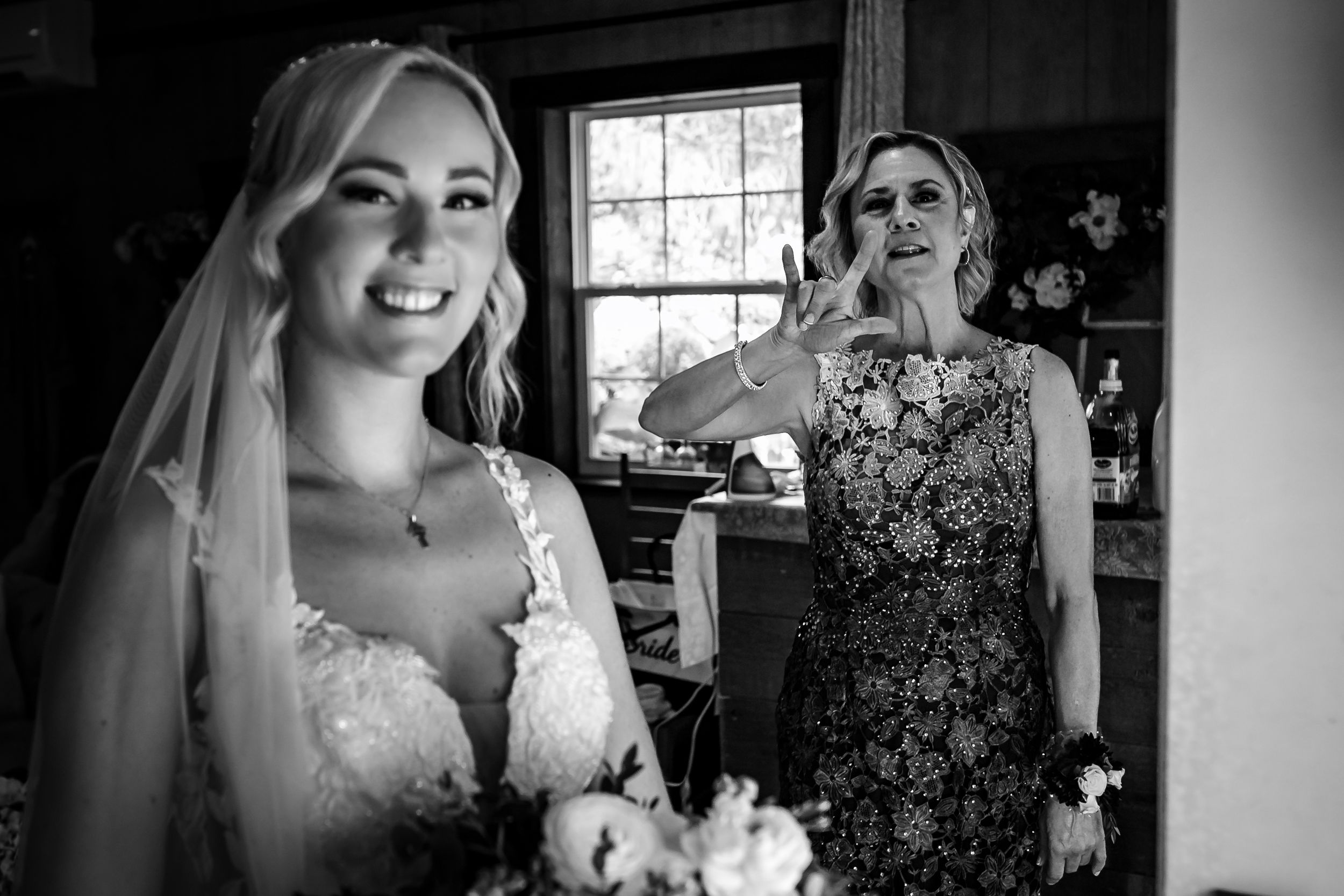 Black and white wedding preparation photos showing emotional moments indoors.