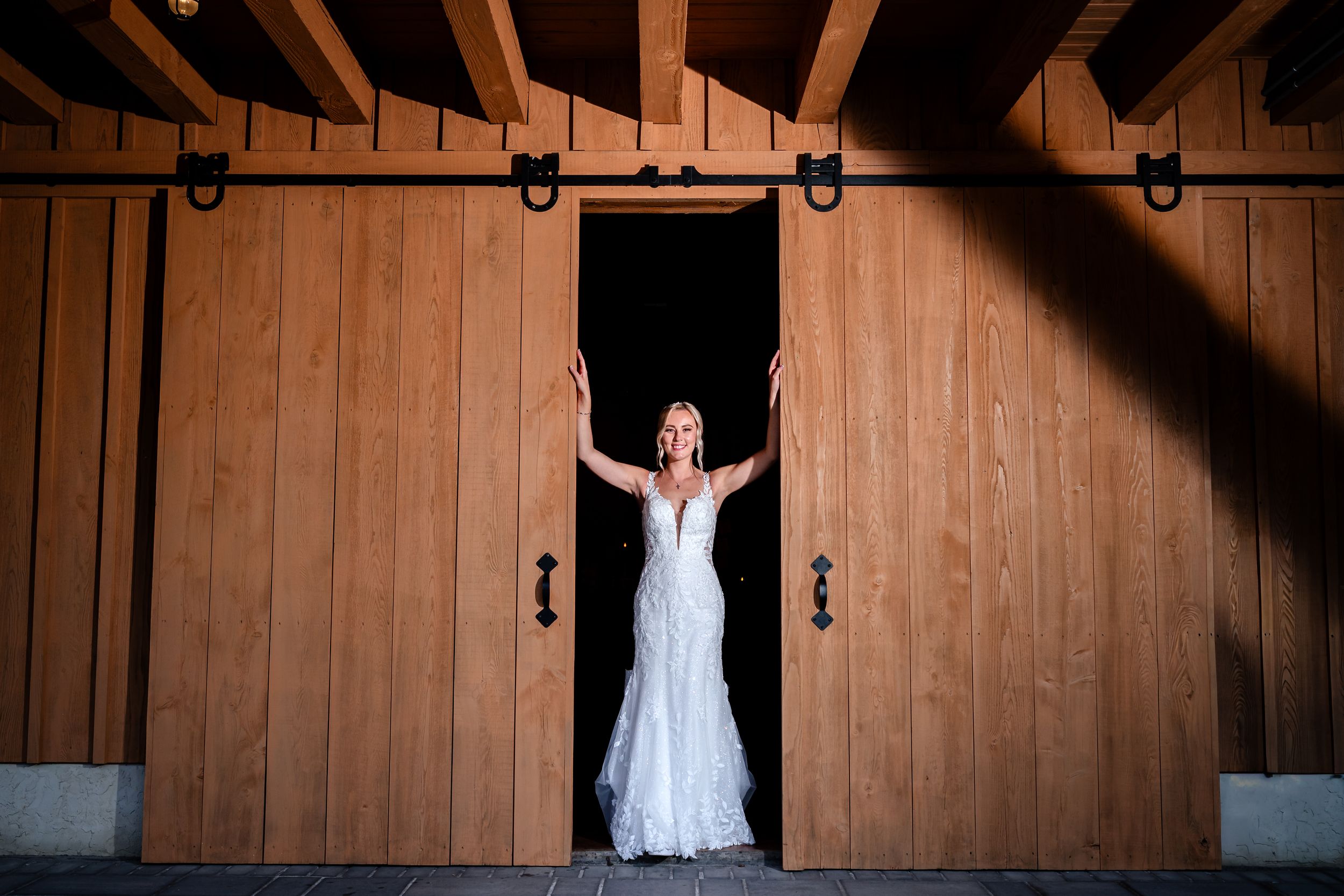 Dramatic silhouette poses against wooden barn walls during wedding photoshoot.