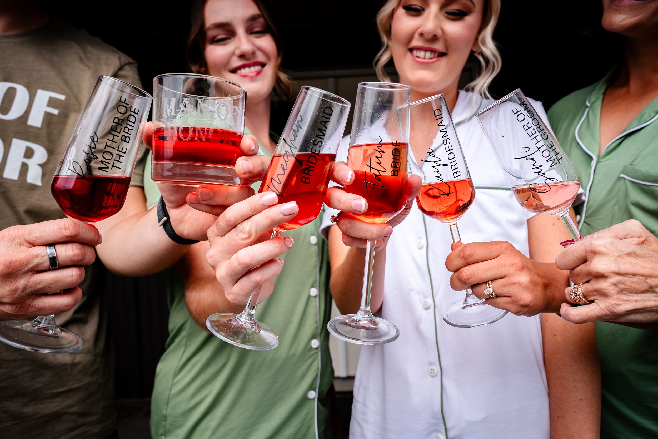 Wedding guests toasting with pink cocktails at a celebration.