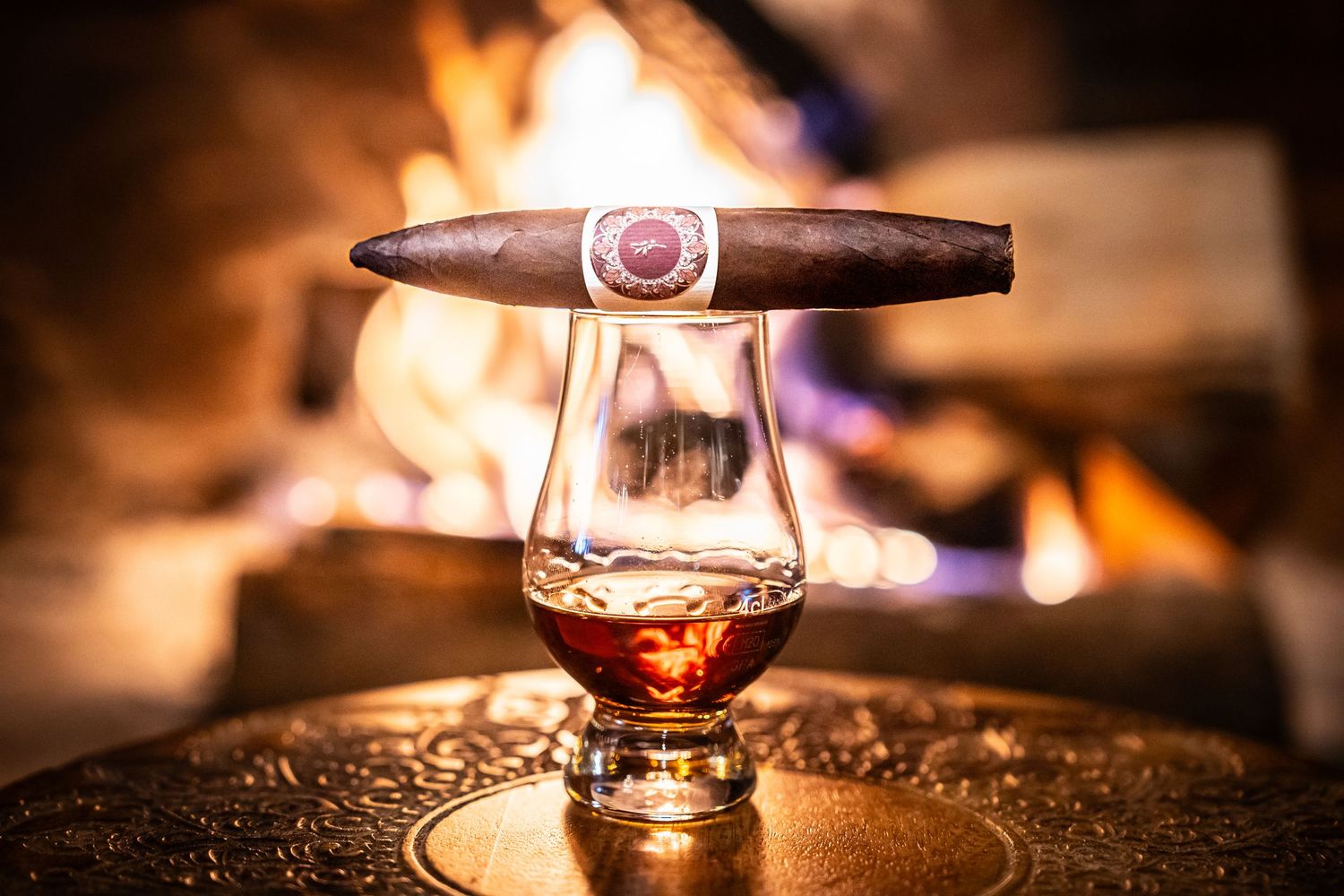 Close-up of glowing cigar with soft bokeh lighting effects in dark setting.