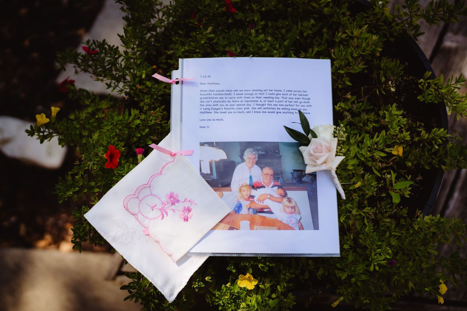 Wedding invitation suite with floral accents scattered in outdoor garden setting.