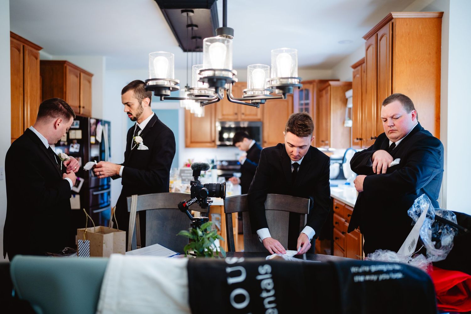 Panoramic view of a group preparing in a hotel room interior with warm wood furnishings.