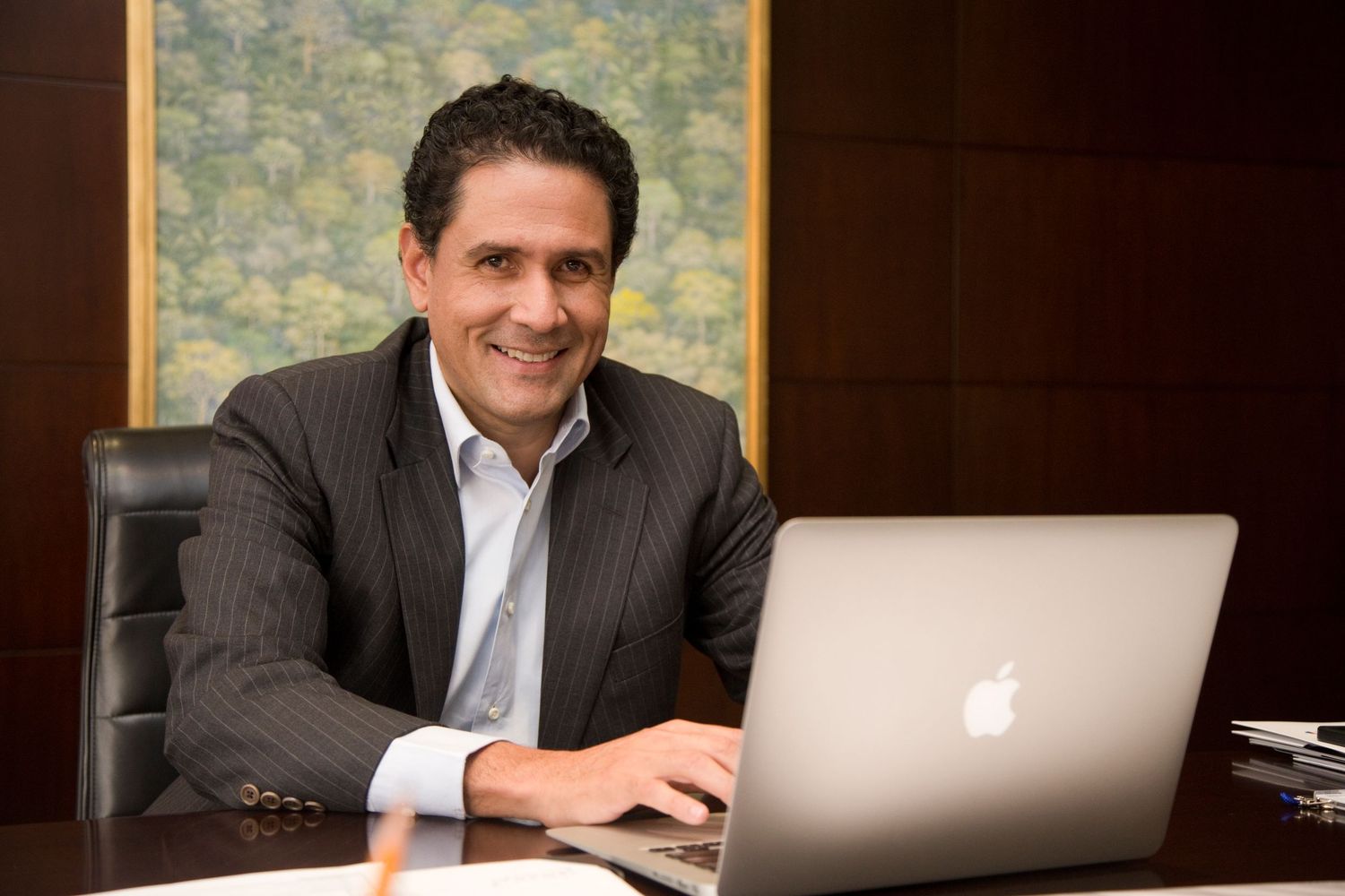 A banker poses for a photo in his office.