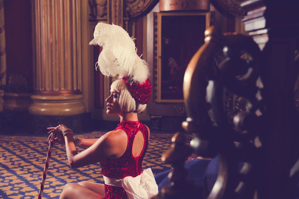Theatrical performance with dramatic lighting in an ornate vintage theater setting.