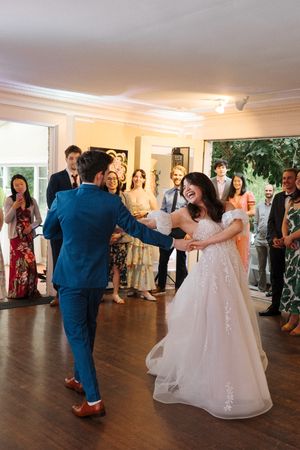 Newlywed couple spins through five romantic dance moves captured in sequence during their wedding reception.