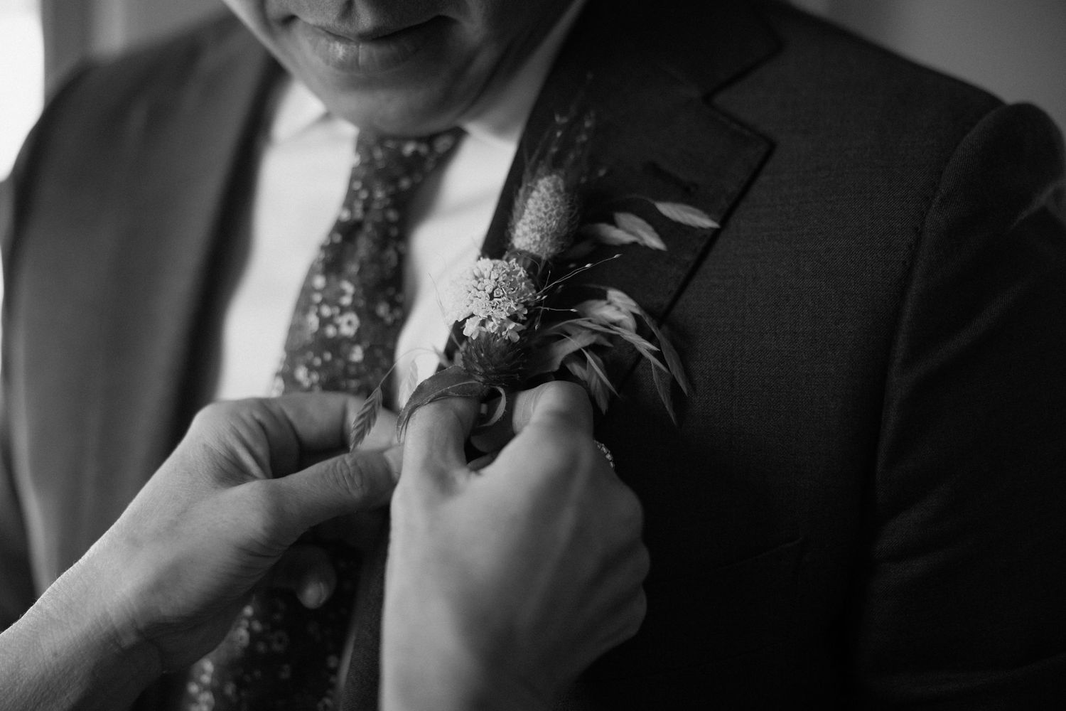Close-up black and white detail of formal attire and accessories.