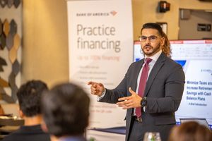 Business professionals gather in a meeting room to discuss financing and practice management strategies.