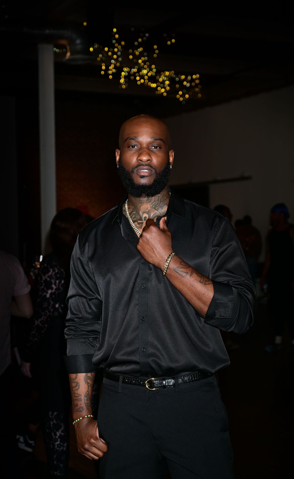 A sequence of candid poses in dark attire at a dimly lit event with string lights in the background.