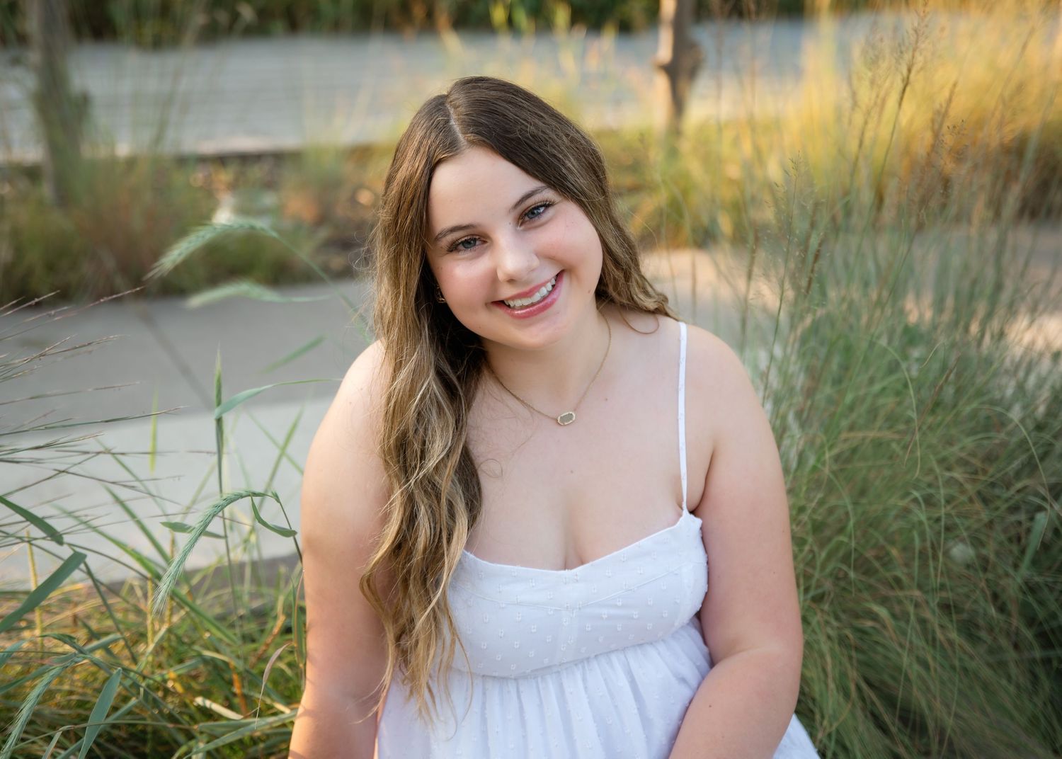 A summertime outdoor portrait session in golden sunlit tall grass.