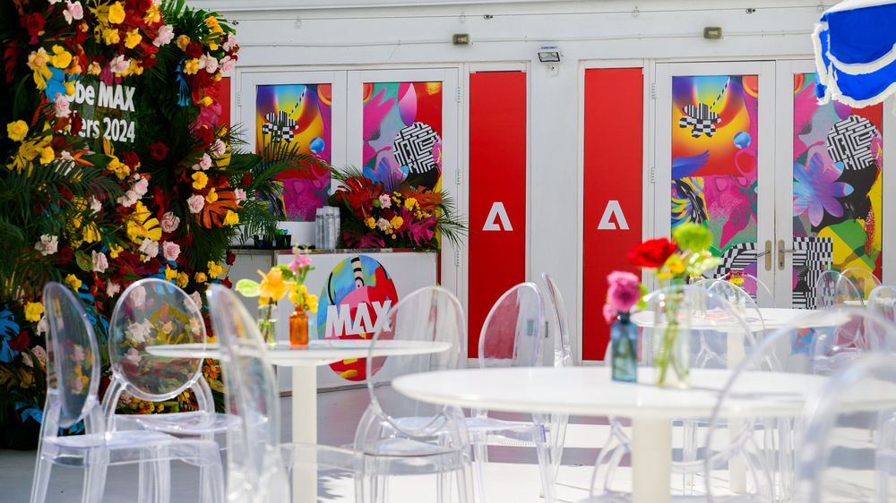 Colorful holiday retail display with clear chairs and festive decorations in front of a white wall with red accents.