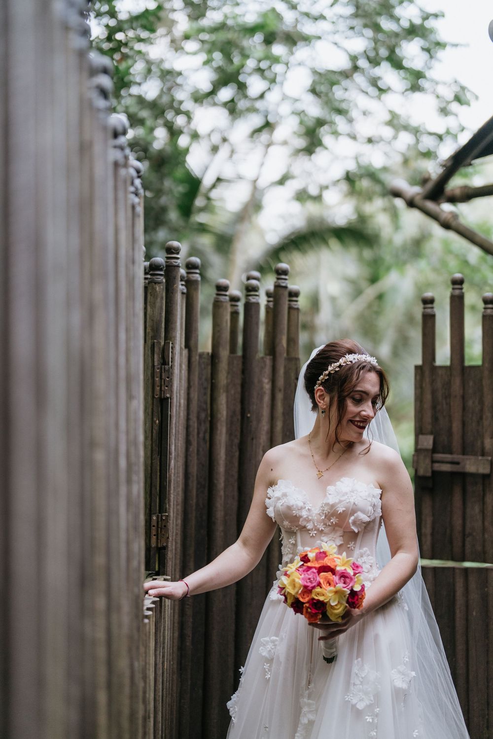 A bridal portrait showcasing an elegant white gown with floral details and a colorful bouquet.