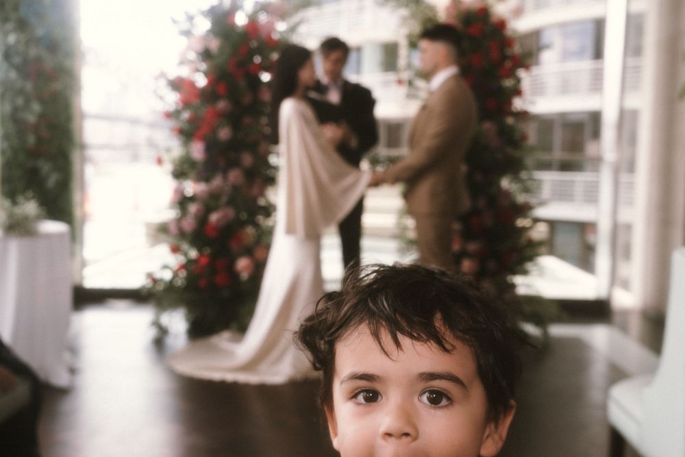 Pink floral arrangements decorate white pillars in what appears to be a wedding venue setting.