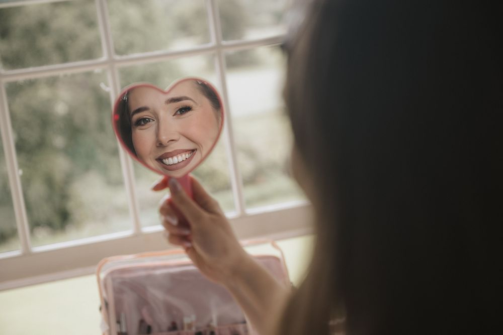 A collage of four soft, dreamy photos showing someone smiling and laughing in warm natural window light.