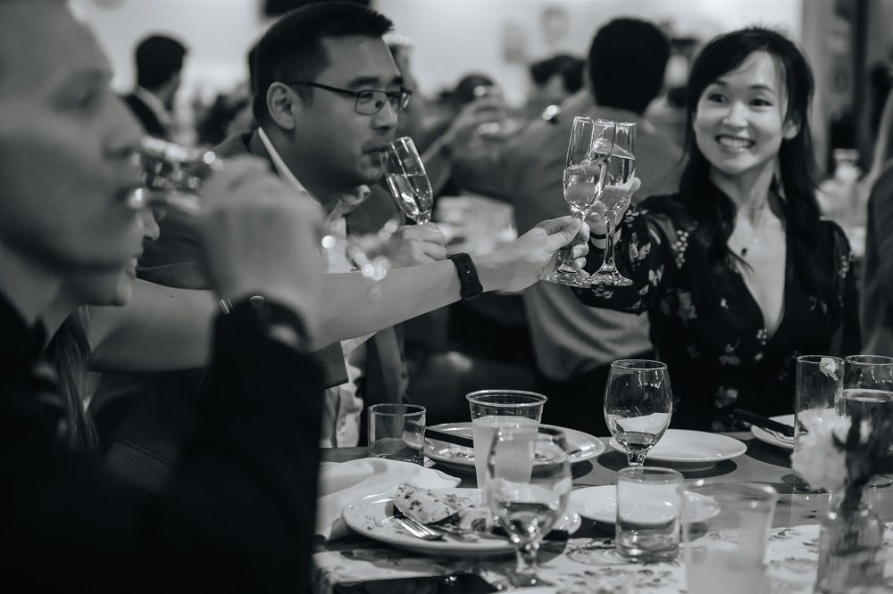 People enjoying dinner at a long table in a restaurant with moody lighting and intimate atmosphere.