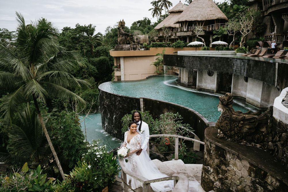 Tropical resort wedding venue with infinity pool and palm trees overlooking lush jungle landscape.