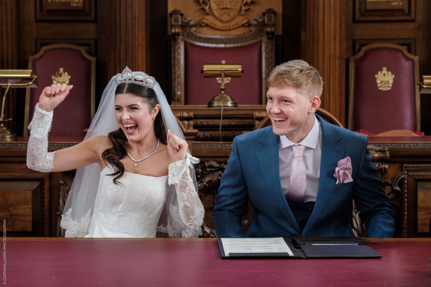 Joyful moments during a wedding ceremony in an ornate wood-paneled hall with elegant decor.