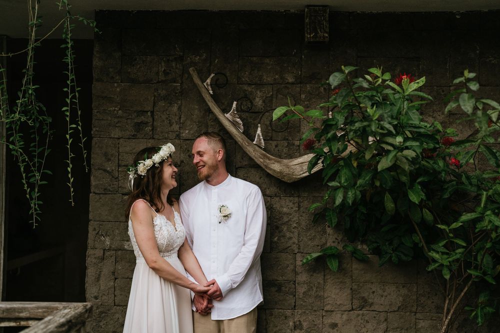 A romantic wedding photo shoot in a lush garden setting with white floral decorations.