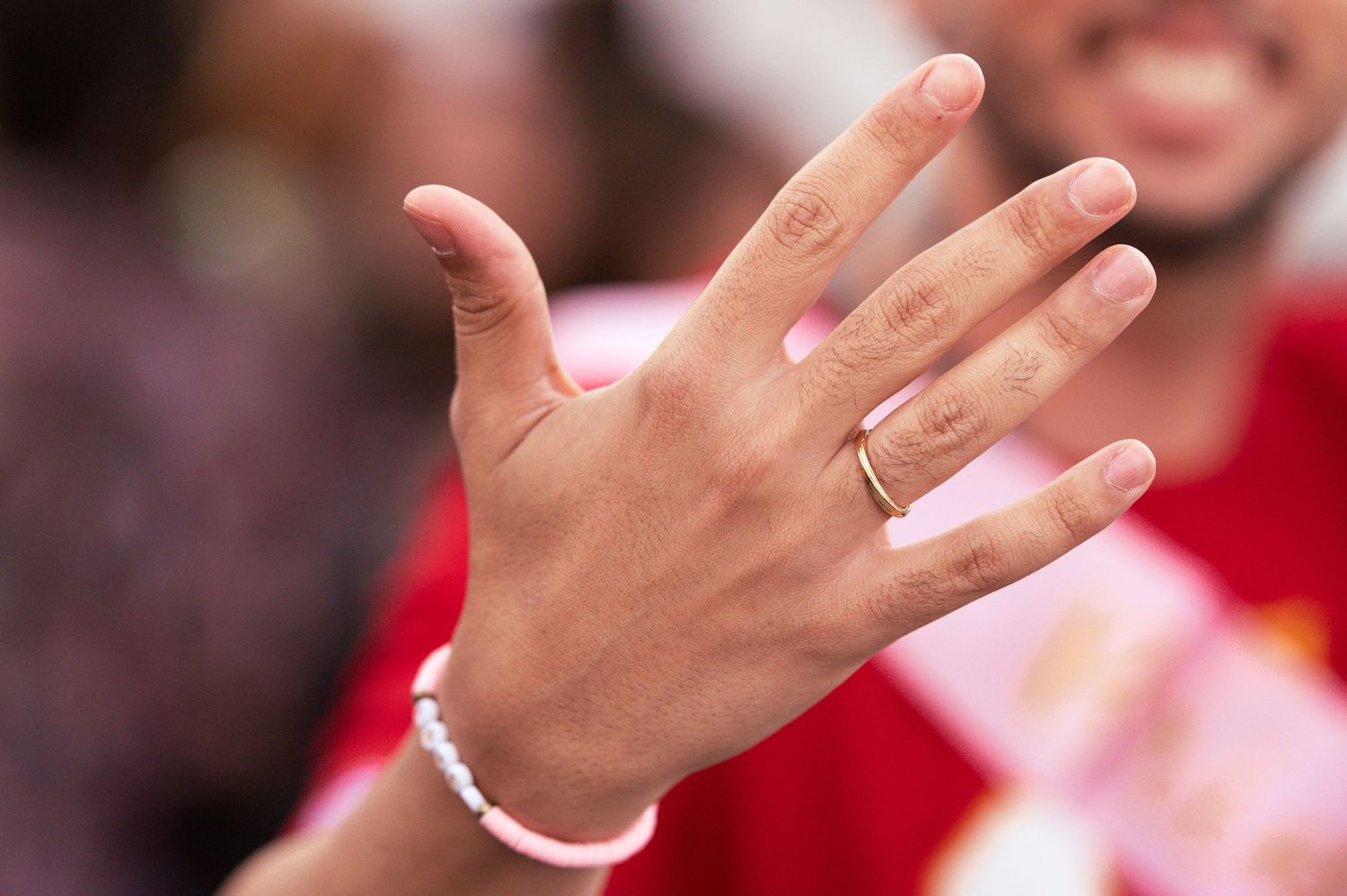 Close-up of hand displaying ring during celebratory moment at sporting event.