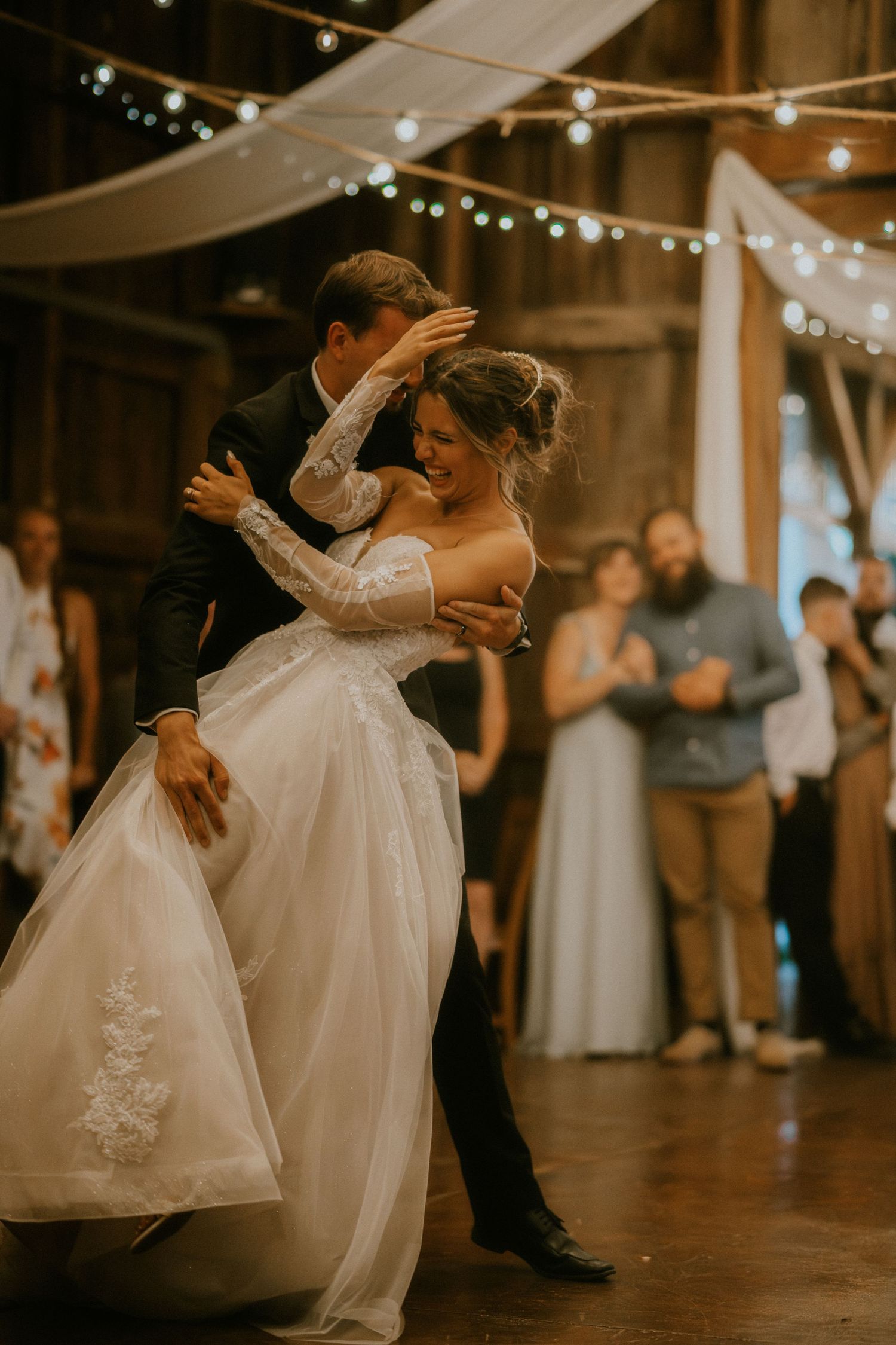A tender dance sequence showing a couple spinning and twirling together on the dance floor at an indoor wedding reception.