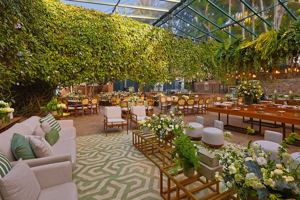 Elegant outdoor dining area with fairy lights, wooden furniture, and lush greenery creating a romantic garden ambiance.