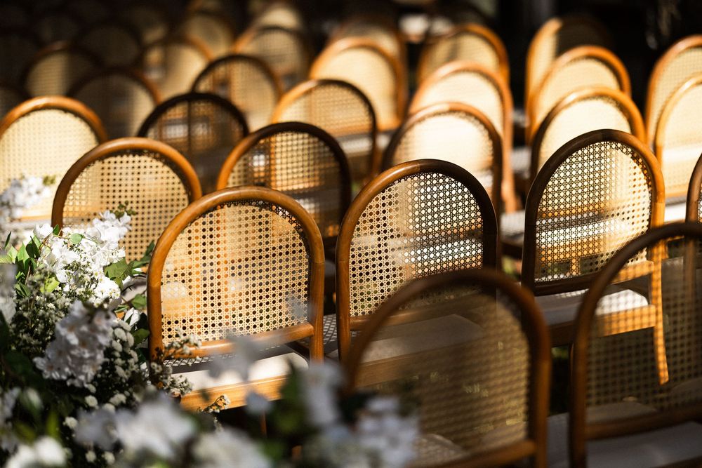 Rattan headboards with caning texture create a warm and repetitive pattern with soft lighting in the background.