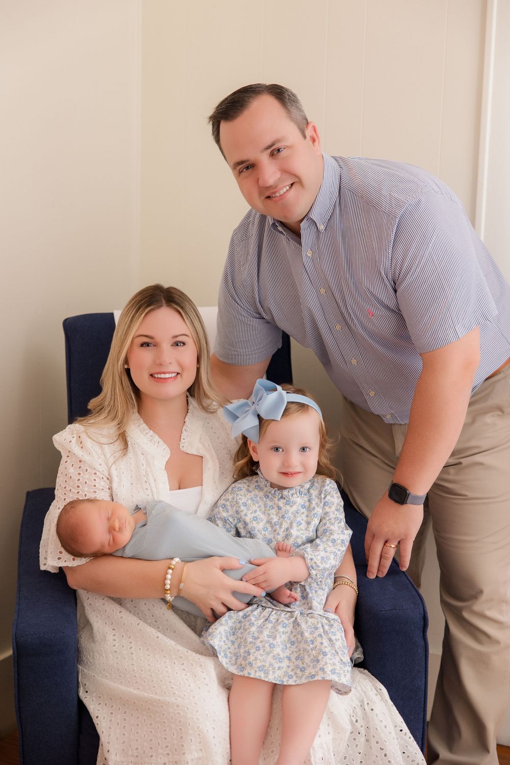 A family in coordinating blue and white outfits sits together on a navy couch in a multi-panel photo series.