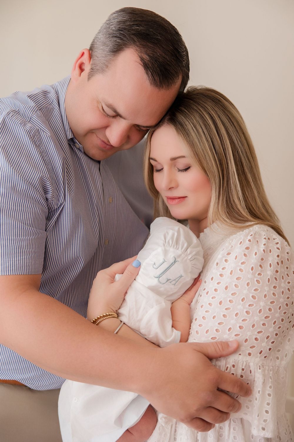 Couple in casual attire sharing tender moments with their newborn baby during an intimate lifestyle photo session.