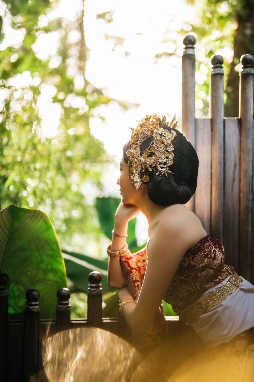 Artistic portrait session in tropical garden with traditional Indonesian attire.