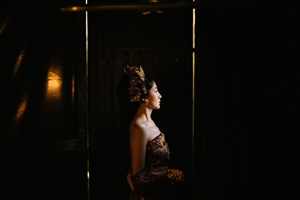 Moody silhouette portrait in dark interior with dramatic side lighting.