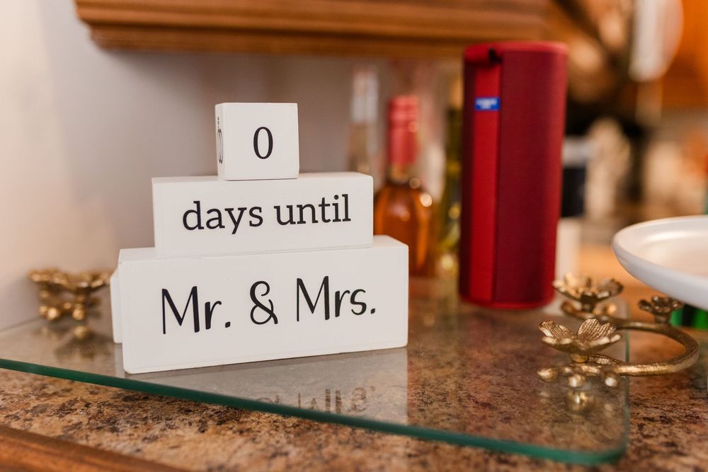 Wedding countdown blocks showing '0 days until Mr. & Mrs.' displayed on a wooden surface with festive decorations.