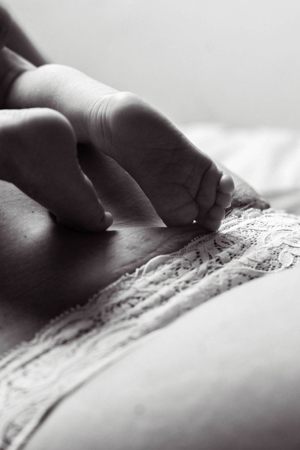Close-up sequence showing fingers pressing and tracing along a delicate lace pattern in black and white.