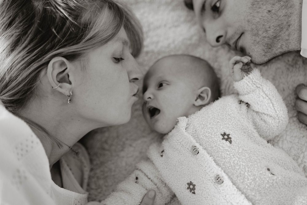 A series of tender black and white photographs showing intimate moments between parent and child.