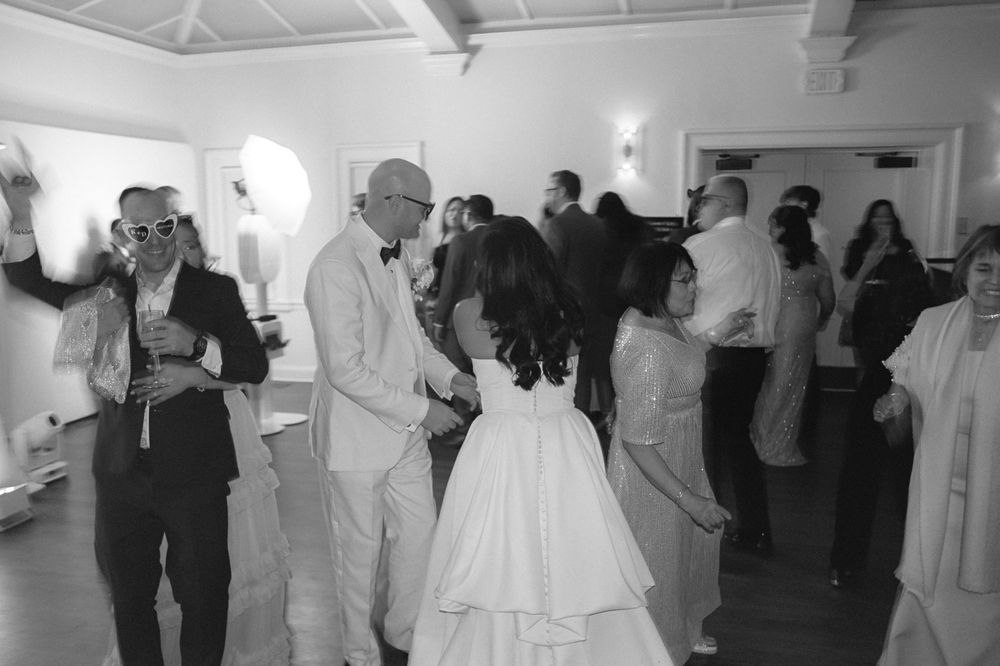 Wedding reception dance floor filled with guests in formal attire.