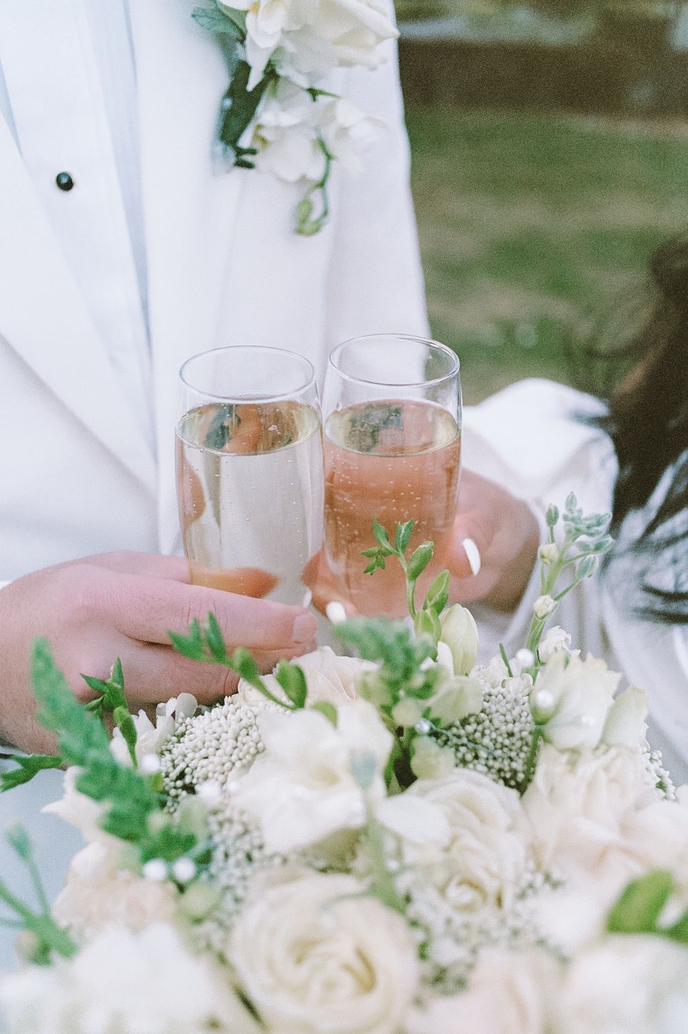 Wedding table setting with white floral centerpieces and champagne glasses.