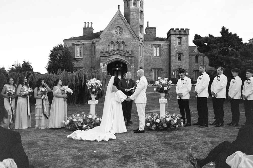 Wedding party lined up outside a historic stone church.