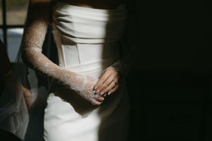 Close-up details of a white wedding dress with delicate lace elements.
