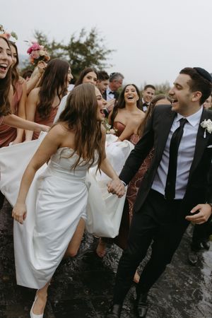 Wedding guests dancing and celebrating together at a lively outdoor reception.