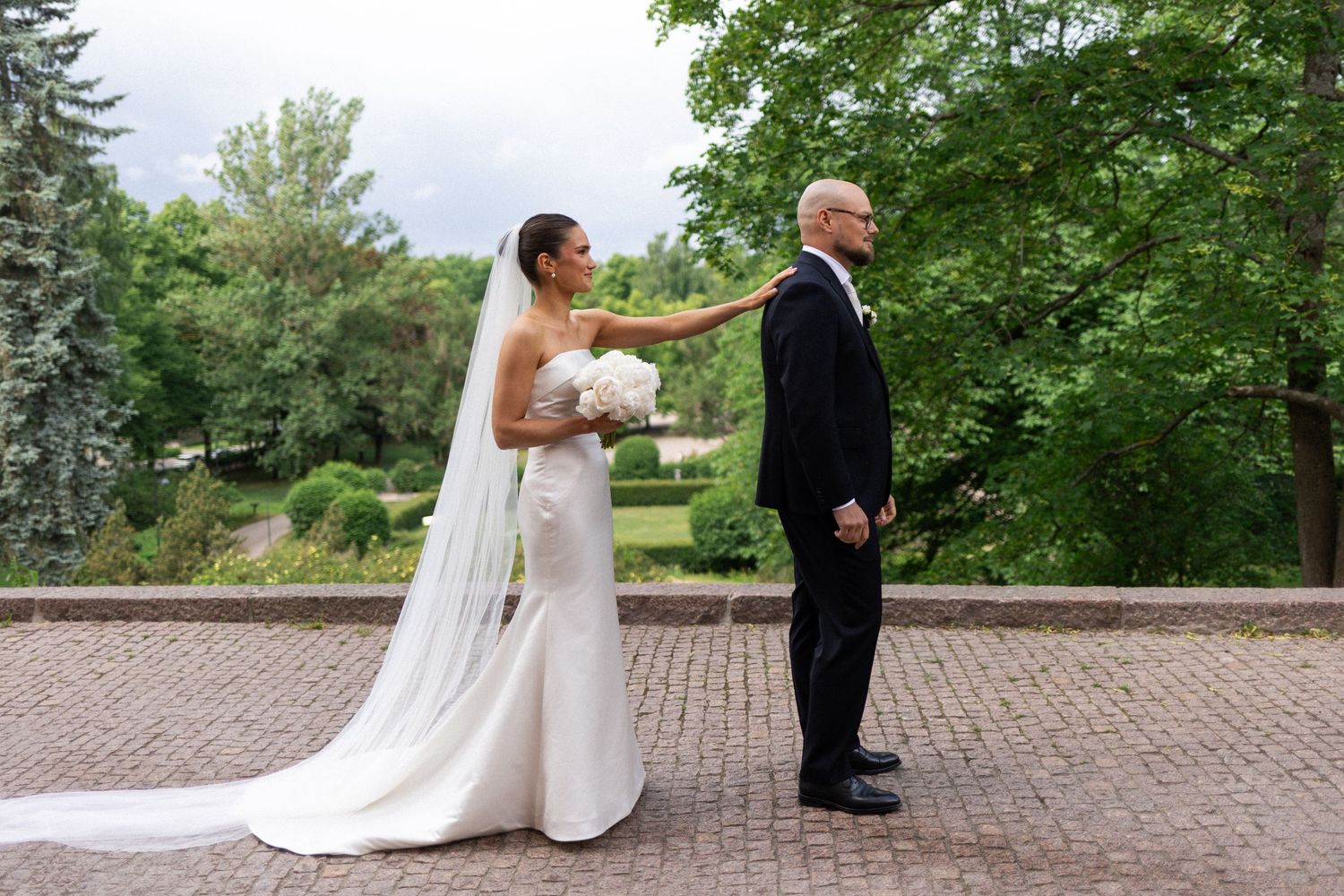 First look moment captured on brick pathway surrounded by lush garden scenery.