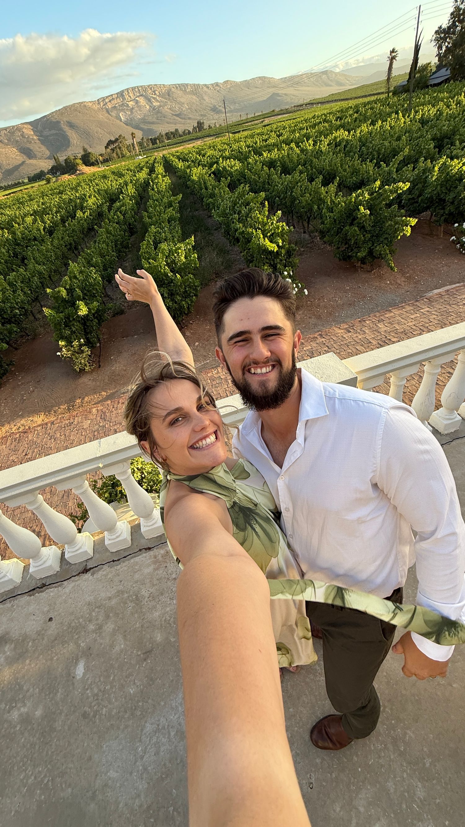 Scenic vineyard terrace overlooking mountains with white balustrade railing at sunset. Auckland Wedding Photographer and videographer