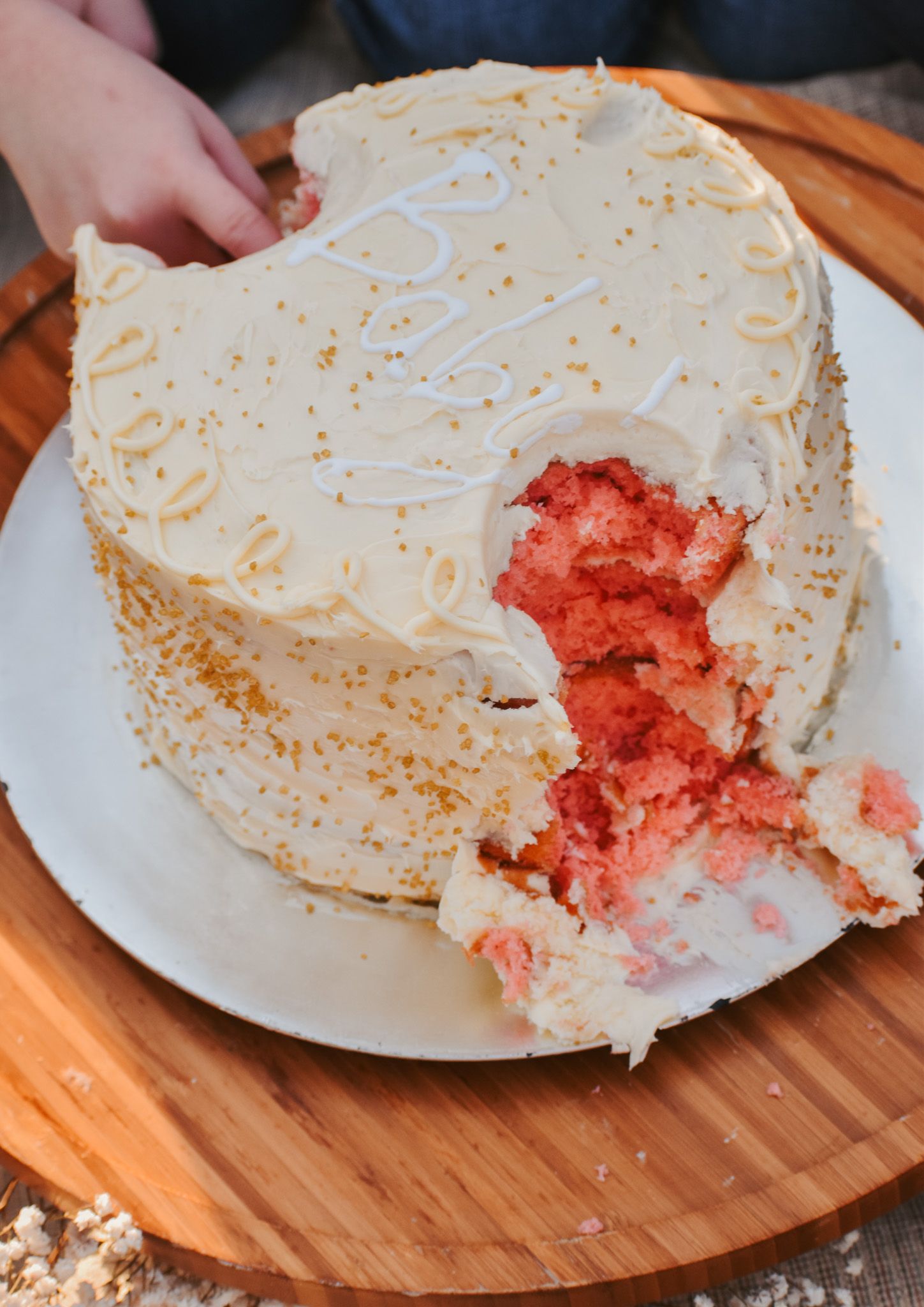 Gender reveal cake with pink interior exposed after being cut.